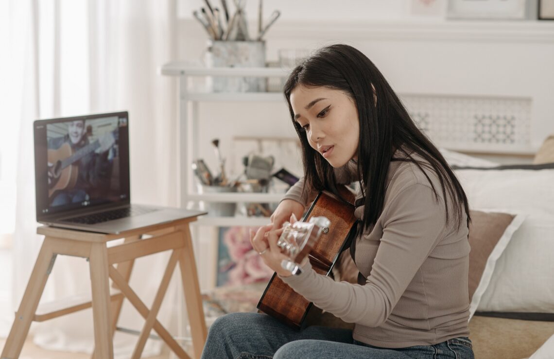 https://www.pexels.com/photo/woman-learning-how-to-play-a-guitar-7120405/
